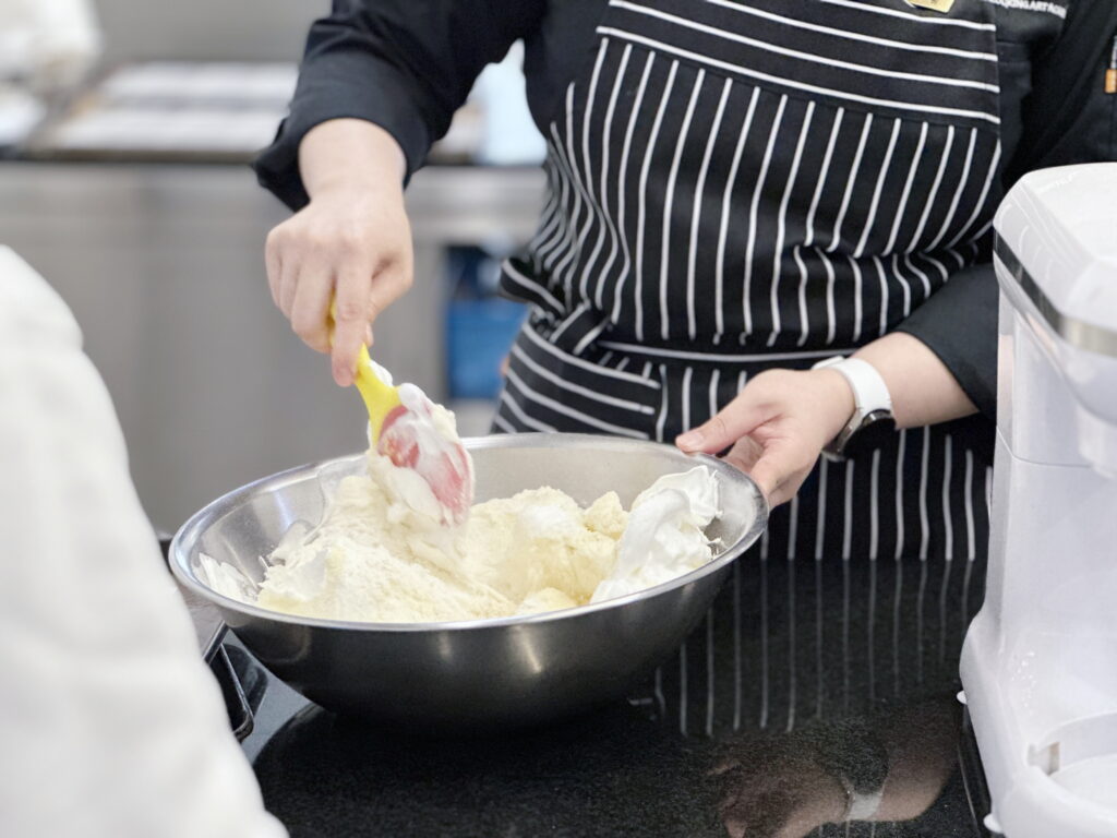 1 베이킹클래스-밀가루 소다 등을 큰 통에 넣고 계속 섞으며 반죽을 만드는 모습