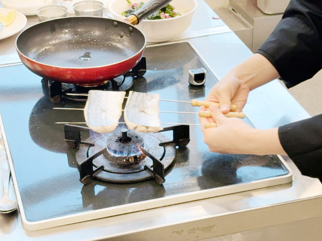 일식조리기능사 : 삼치에 쇠꼬치를 부채꼴 모양으로 끼우는 손동작 클로즈업 또는 노릇하게 구워지는 장면