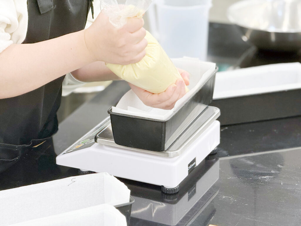 제과기능사-반죽을 짤주머니(깔때기 모양)에 담아 틀에 짜 넣는 사진