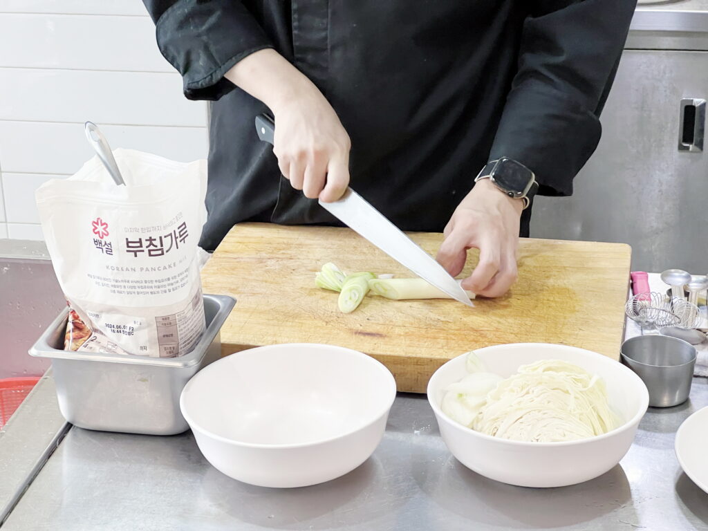 일식 쿠킹클래스를 진행하는 요리학원 강사님이 오코노미야끼 원데이클래스 수강생들을 위해 대파와 양배추를 손질하는 모습