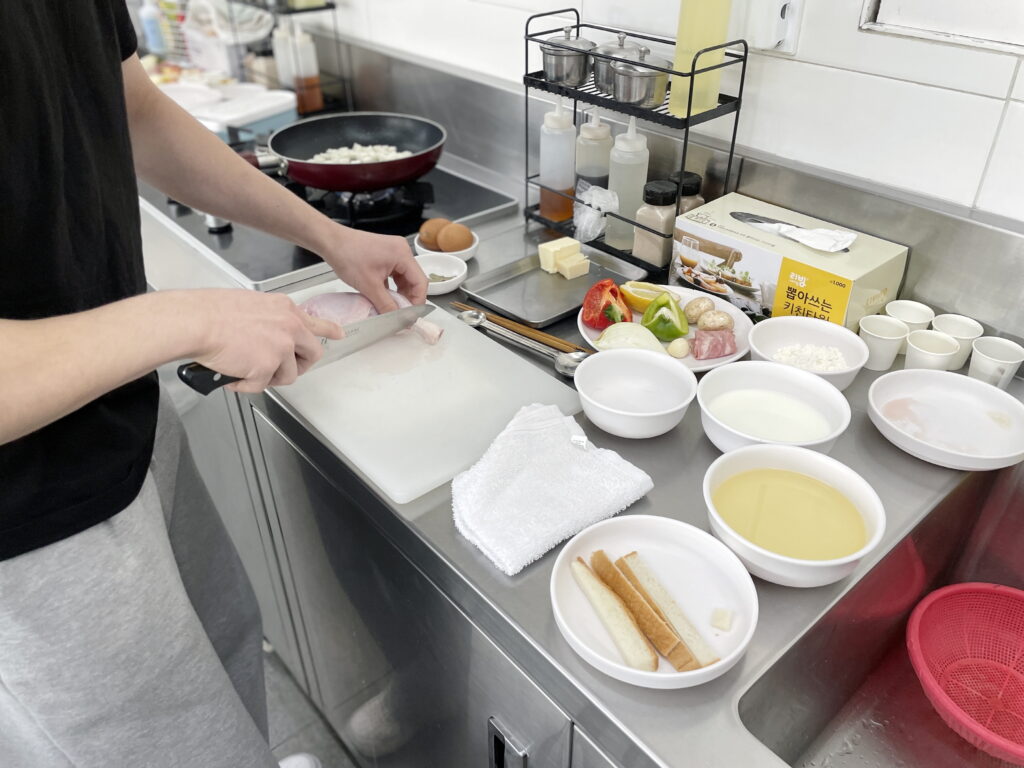 수강생이 도마 위에서 닭의 뼈와 살을 정교하게 분리하고 있는 모습