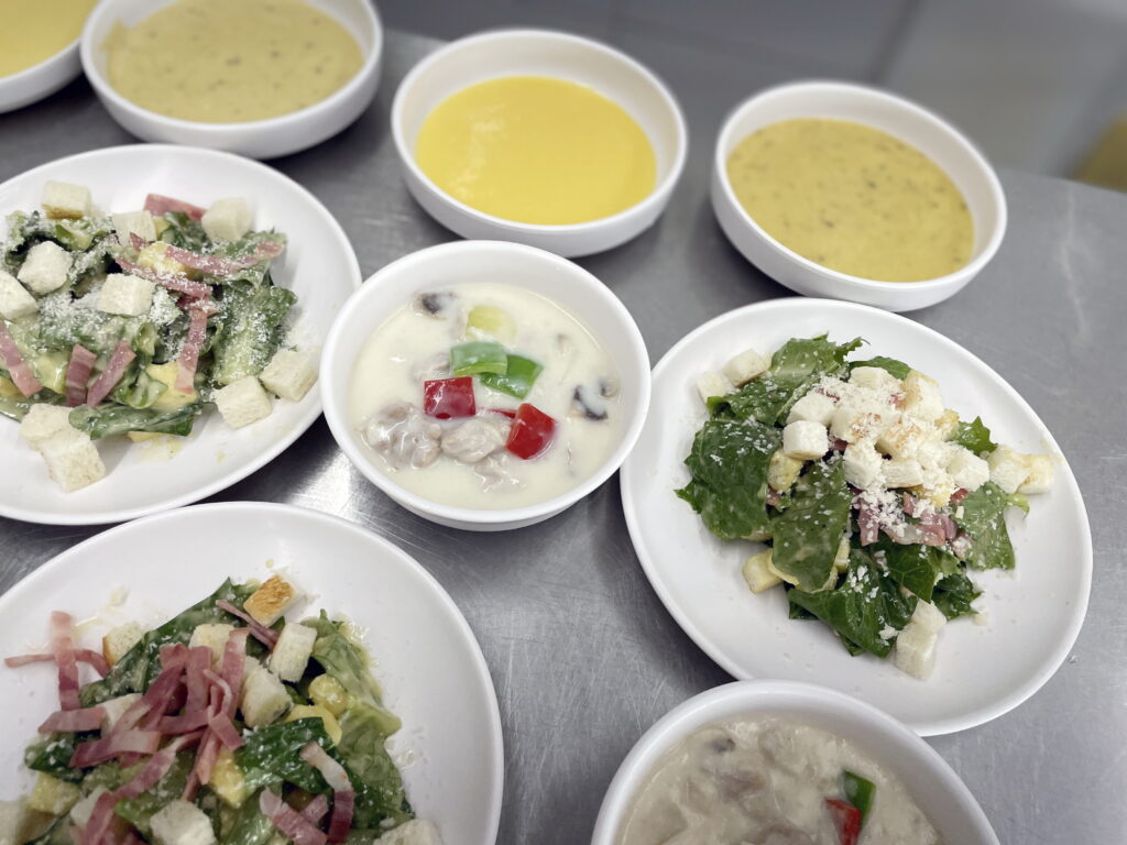 완벽한 1.8cm 큐브 모양이 살아있는 치킨 알라킹과, 눈꽃 치즈가 뿌려진 시저 샐러드의 근접 플레이팅 사진